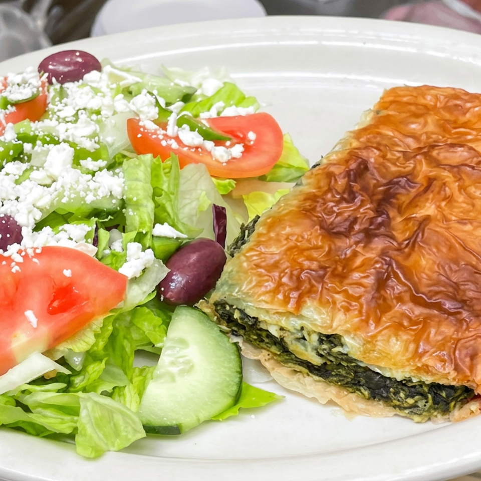 Golden spinach-filled puff pastry served with a Greek salad of lettuce, tomatoes, cucumber, olives, and feta.